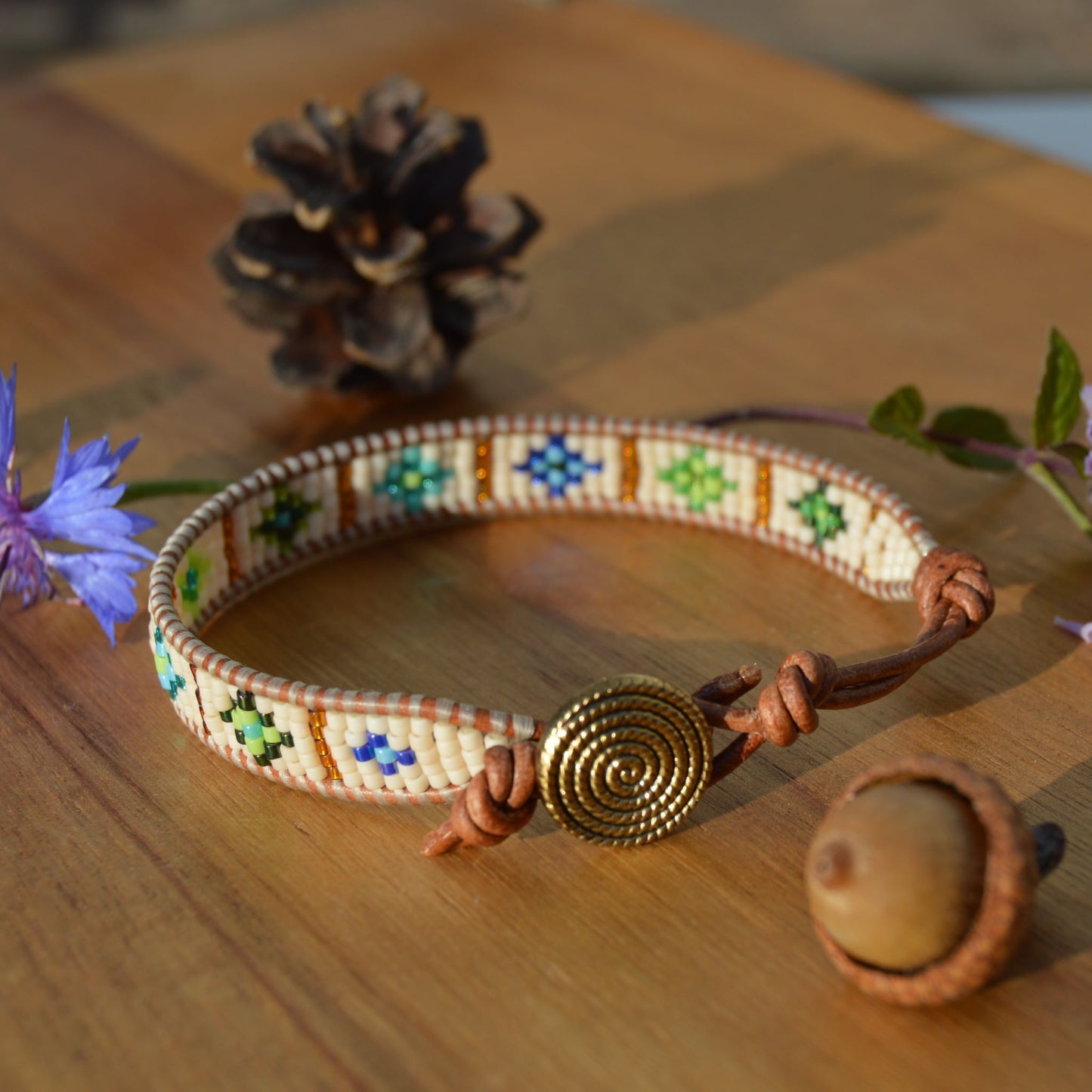 Leather wrap bracelet with woven seed beads in green & blue tones.