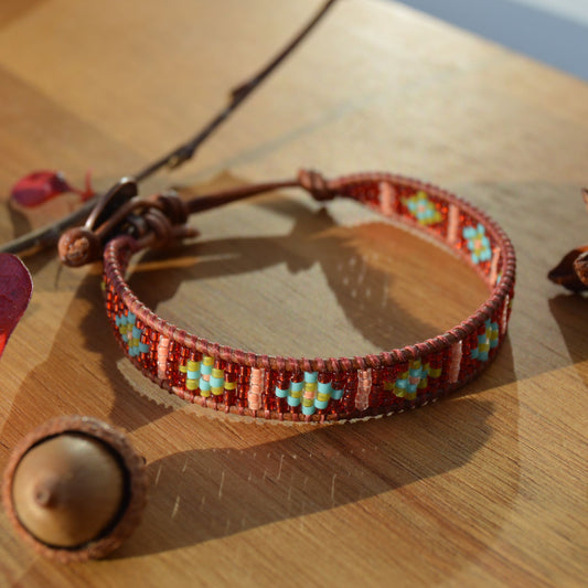 Leather wrap seed beads bracelet with button in copper colour as a lock and extension in leather.